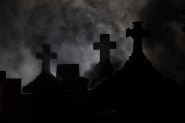 Headstone cross in Graveyard at night.