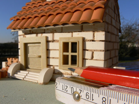 Modellhaus im Rohbau mit Meter und Blei