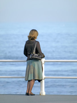 Mujer con falda mirando al mar