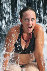 Obraz premium A young woman under a waterfall at a luxury resort in Costa Rica