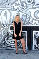 Fototapeta na wymiar Portrait of a gorgeous young woman against a wall of graffiti