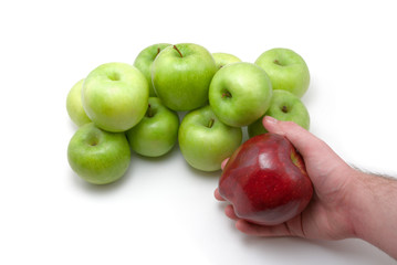 green apples on white and red apple in hand of man