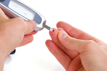 Diabetic is doing a glucose level finger blood test.