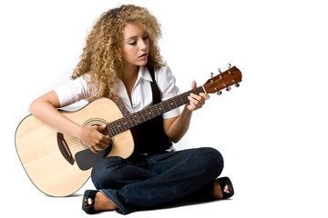 Fototapeta premium A pretty young woman playing acoustic guitar 
