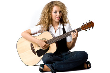 A pretty young woman playing acoustic guitar