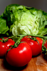 Légumes : tomates, carottes et salades sur planche de bois
