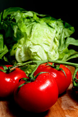 Légumes : tomates, carottes et salades sur planche de bois
