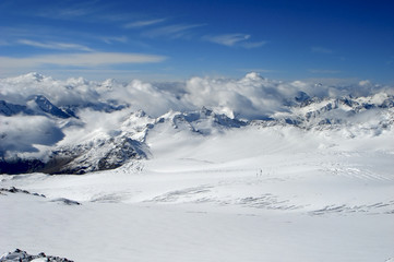 Fototapeta na wymiar Snow-covered tops on a background of the blue sky