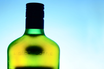 part of old liquor bottle over cloudness sky