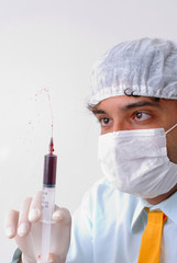 Doctor using mask and holding a syringe.