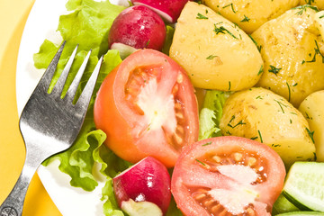 tasty boiled potatoes with tomato, radish and lettuce