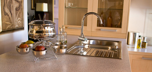 Kitchen sink with the crane and Utensils for fondue