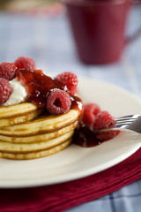 Delicious small american pancakes with raspberries 