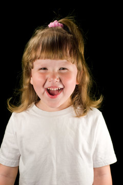 Excited laughing child wearing white t-shirt looking at you