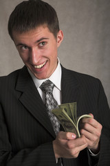 young successful businessman with money on the gray