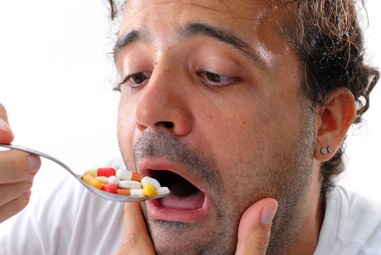 Man Eating Pills With A Spoon . Self Medication .