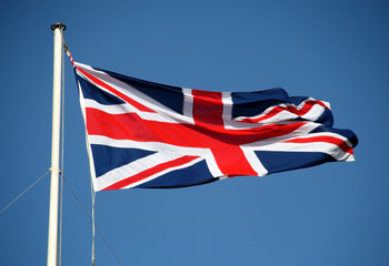 The Union Jack Flag flying from a Flagpole in the wind 