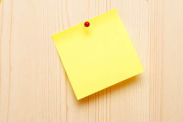 yellow sticky note on wooden background