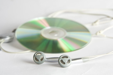 Grey and black earphones and compact disc