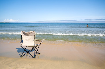 The chair stands on sandy coast.Evening..