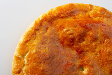 Golden pie close up on a white background