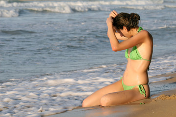 Frau sitzt am Meer