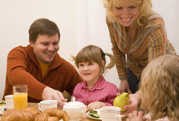 Obraz na płótnie Canvas Happy family have a breakfast at the table 