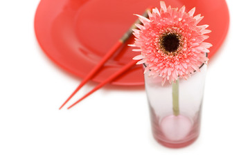Red flower and plate with chopsticks isolated on white