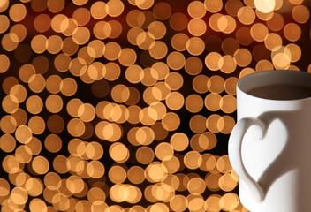 cup with shadow heart on bokeh lights