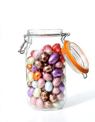 glass jar with chocolate easter-eggs, on white - 6523377