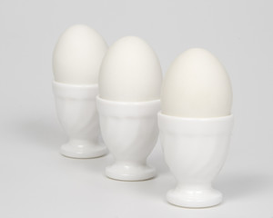 Three white eggs in eggcups