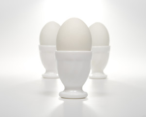 Three white eggs in eggcups