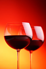 Wine glasses against red background