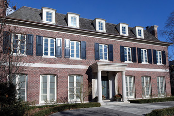 large brick house with portico and shutters