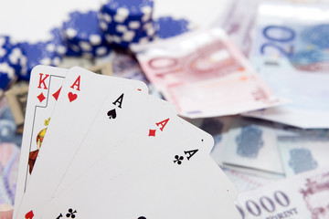 Poker hands - cards have focus with poker chips and money
