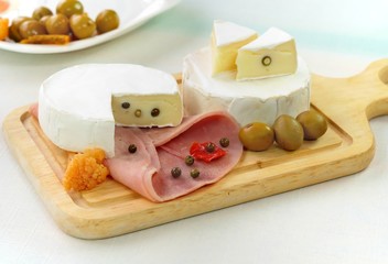 Two loaf of french cheese Camembert with olive and pepper