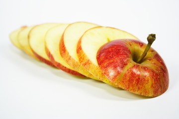 Nahaufnahme von einem frischen Apfel,  in Scheiben geschnitten, auf weißem Hintergrund.