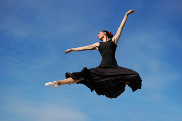 Dancer jumpimp against blue sky