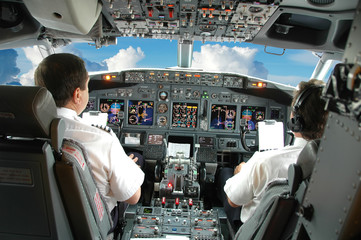 Pilots in the cockpit - obrazy, fototapety, plakaty
