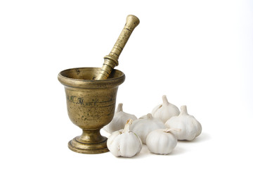 bronze mortar with bulbs of garlic, isolated on white background