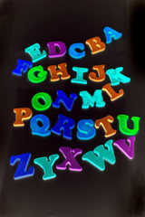 Alphabet letters over black background