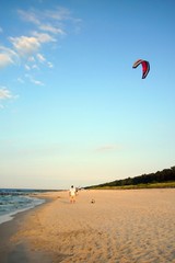 kiteboarder preparing his kite on a beach