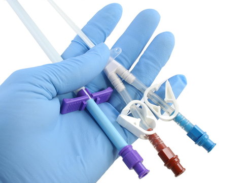 gloved hand holding a catheter and introducer