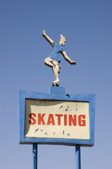 Pigeon on top of roller skating rink sign