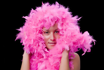 Beautiful womans face hiding in pink feathers