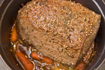 Beef roast and carrots simmering slowly on the stove