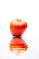 Ganzer roter Apfel spiegelt sich im Wasser