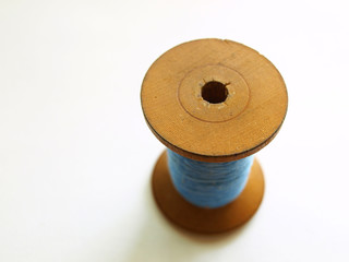 Blue thread on wooden bobbin