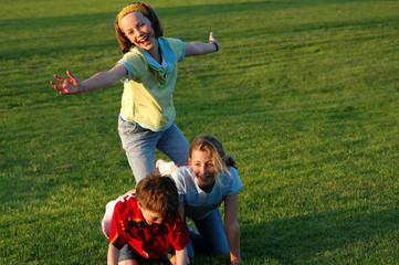 children climbing on each other at park