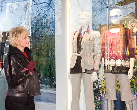 The young woman examining a show-window of shop